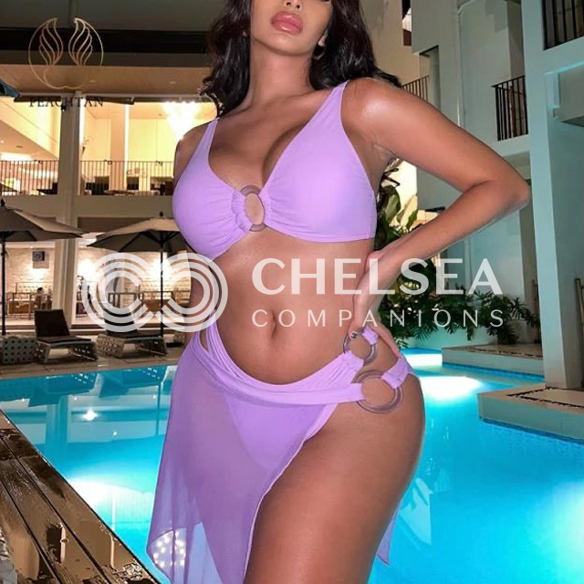 Alaya wearing a purple bikini stood in front of a pool